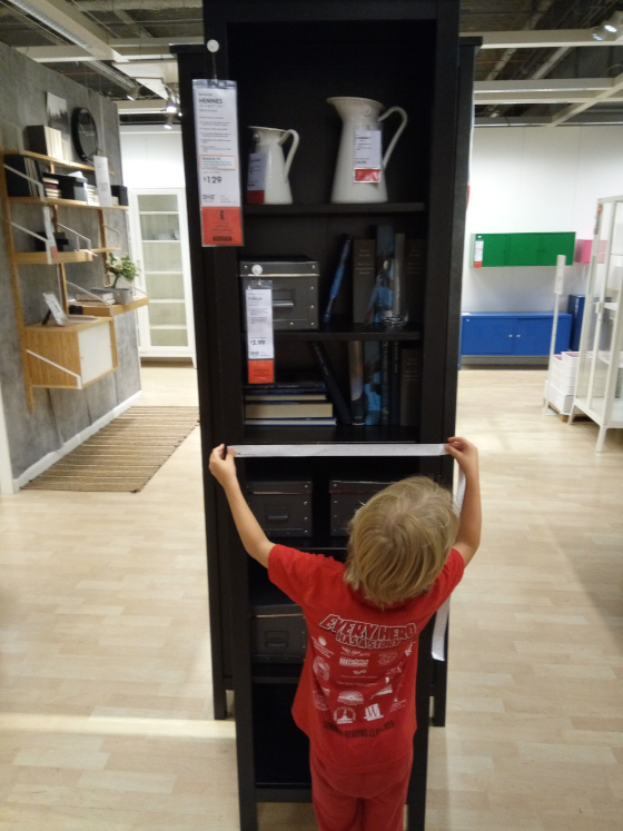 easy field trip: child measuring bookshelf in ikea